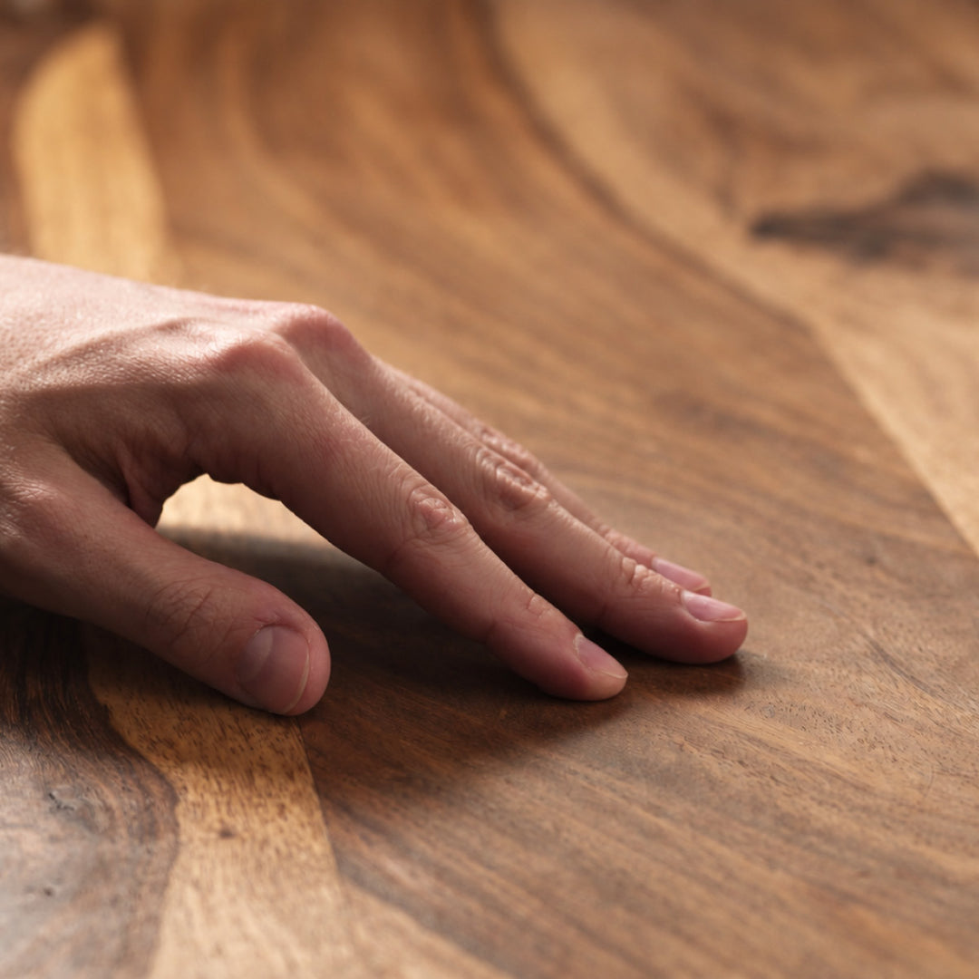 Hand ertastet die samtige Oberfläche eines mit OLI NATURA Möbelwachs gepflegten Holzes