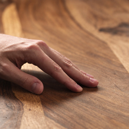 Hand ertastet die samtige Oberfläche eines mit OLI NATURA Möbelwachs gepflegten Holzes
