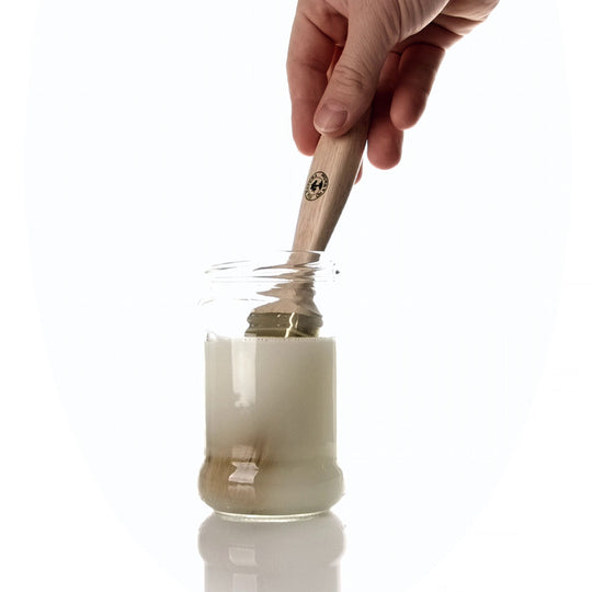 Pinsel wird in einem Glas mit OLI NATURA® Pinselreiniger durchgearbeitet
