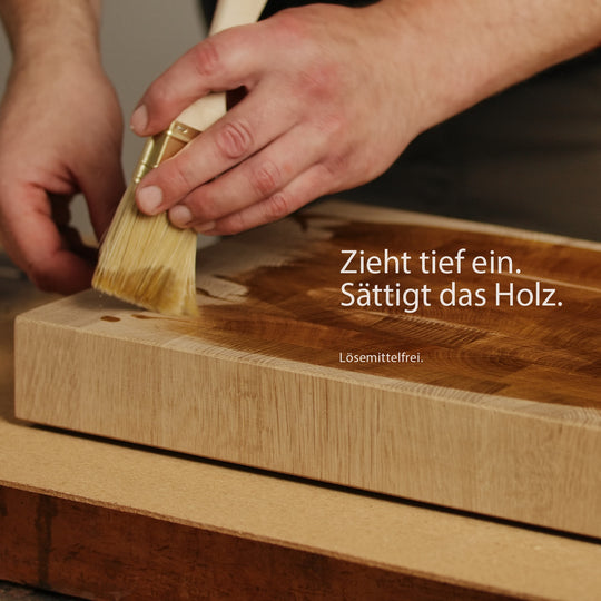 Geöltes Stirnholz-Schneidebrett mit Brot und Küchenutensilien. OLI-NATURA Leinöl-Firnis ist lebensmittelkontakt-geprüft und für Küchenholz geeignet.